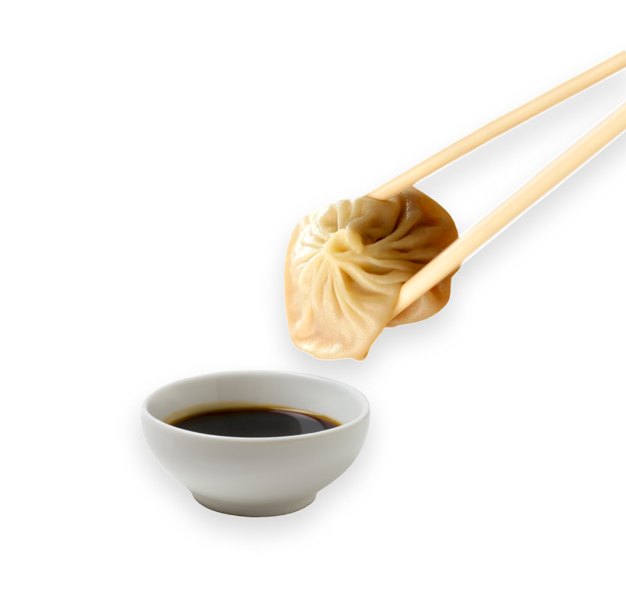 An image of a dumpling and chopsticks being dipped into soy sauce.