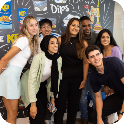 A group of people posing in front of a chalkboard wall.