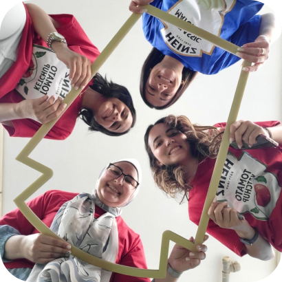 A group of women holding up a paper cut out.
