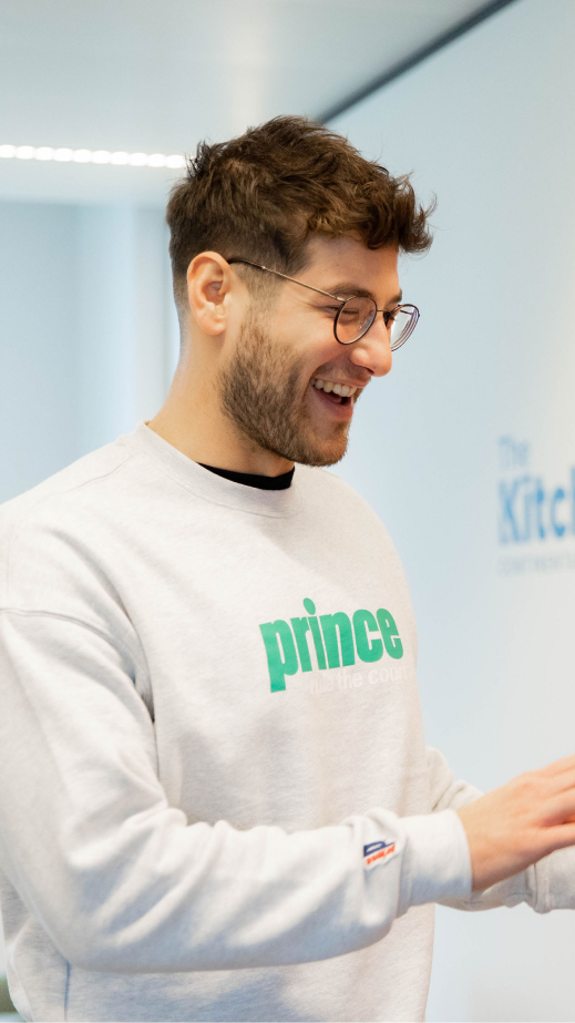 Man in a white sweatshirt laughing