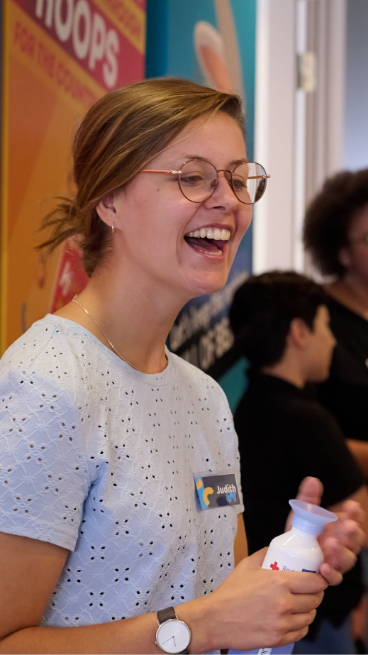 a woman in glasses smiling with a water bottle in her hands
