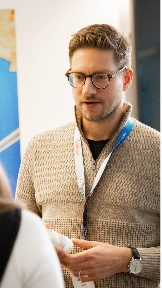 A man holding a bottle of sauce in mid-conversation