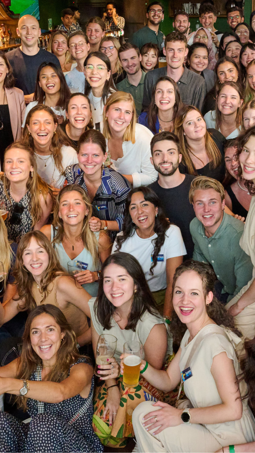 A large group of people in a bar smiling and posing for a photo.