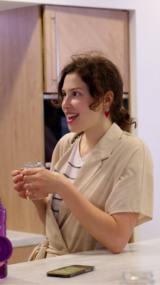 Two women standing in a kitchenette having a conversation.