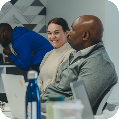 a man and a woman who is smiling, seated at a table