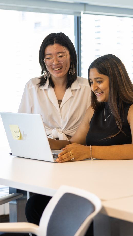2 women looking at a shared laptop screen together