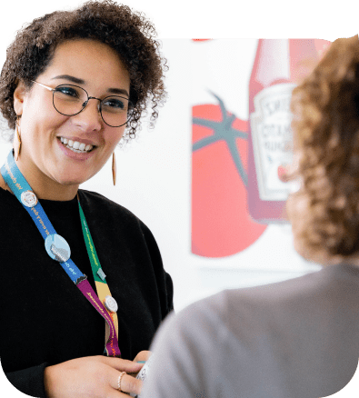 A woman is talking to another woman at an event.